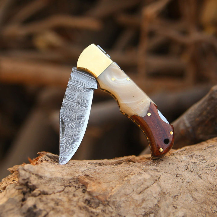 Handcrafted knife with a wooden handle and gold accents on a wooden surface