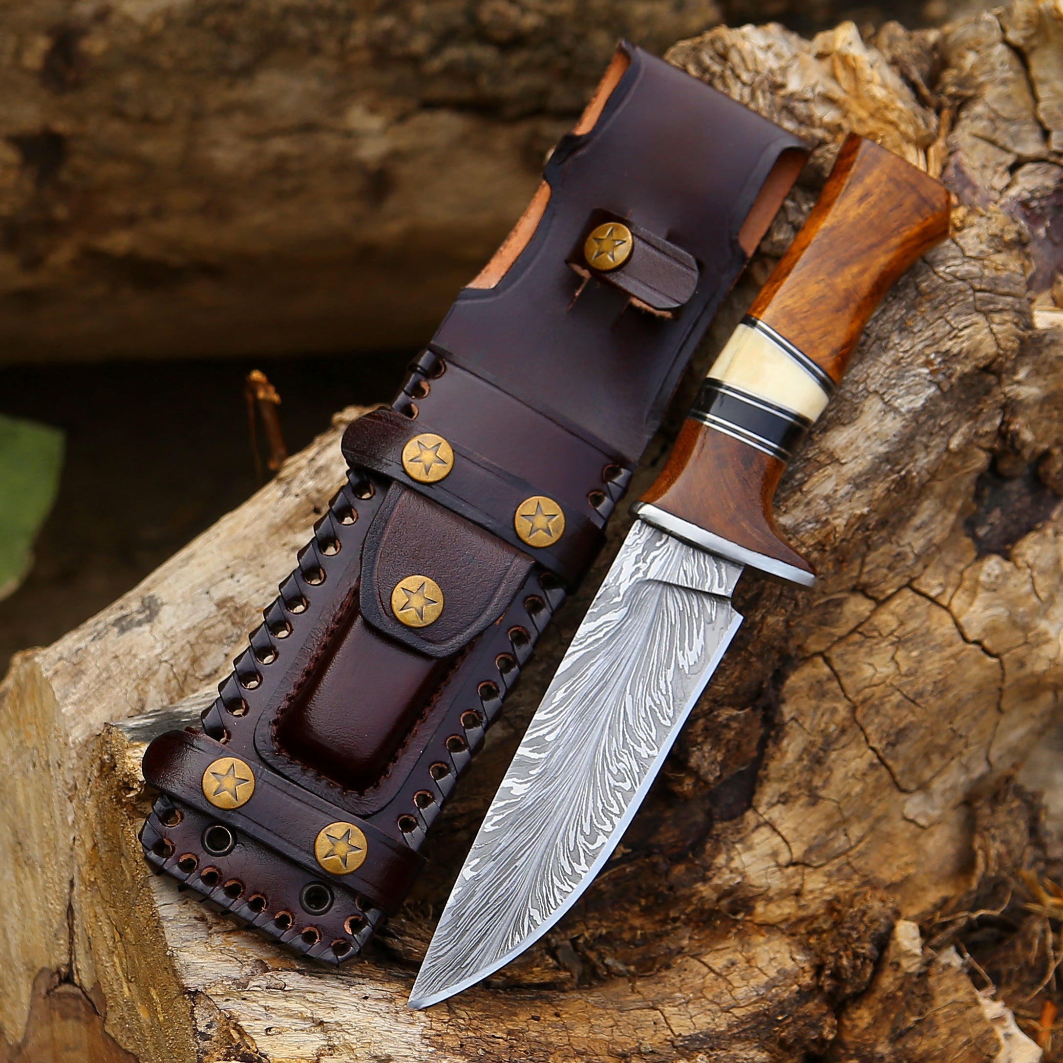 Decorative knife with a wooden handle and leather sheath on a wooden surface