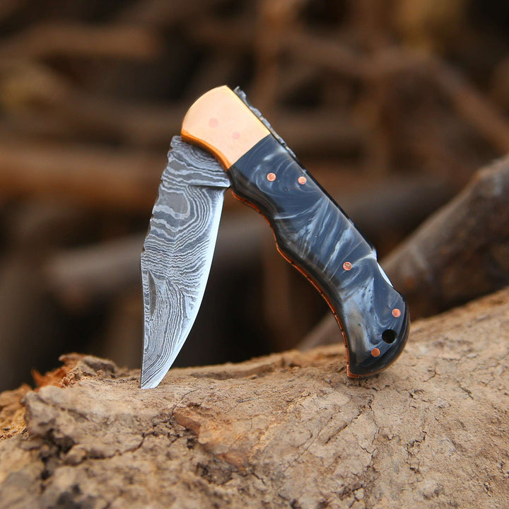Forked blade knife with custom handle on a wooden surface