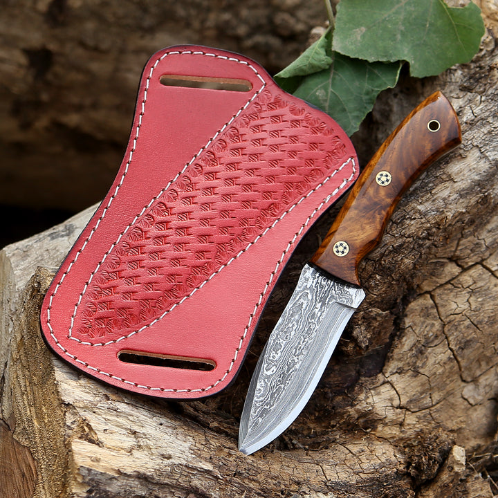 Red leather sheath with a knife on a wooden surface