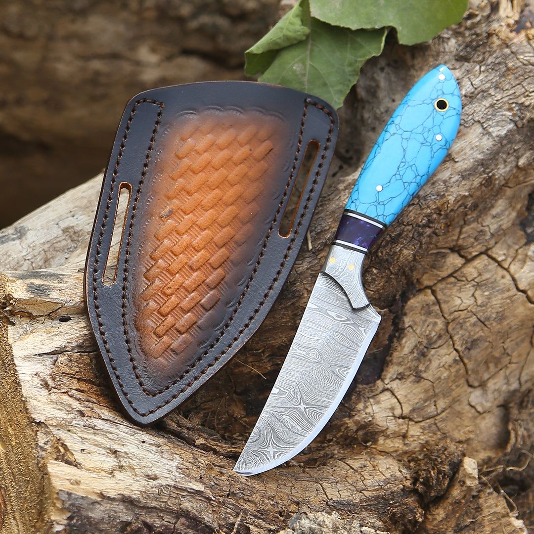 Knife with blue handle and leather sheath on a wooden surface