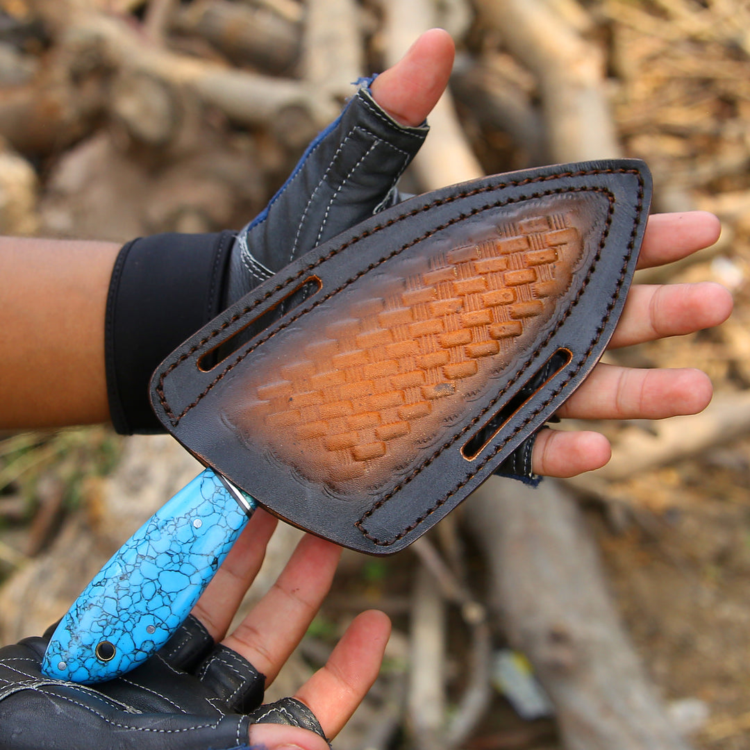 Person holding a knife with a textured brown blade and blue handle against a natural background.