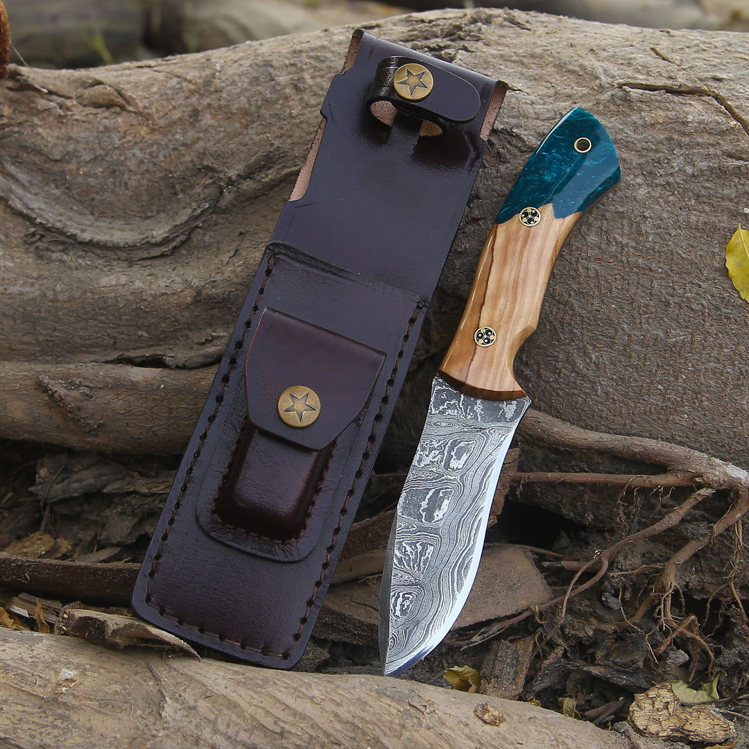 Knife with wooden handle and leather sheath on a natural background
