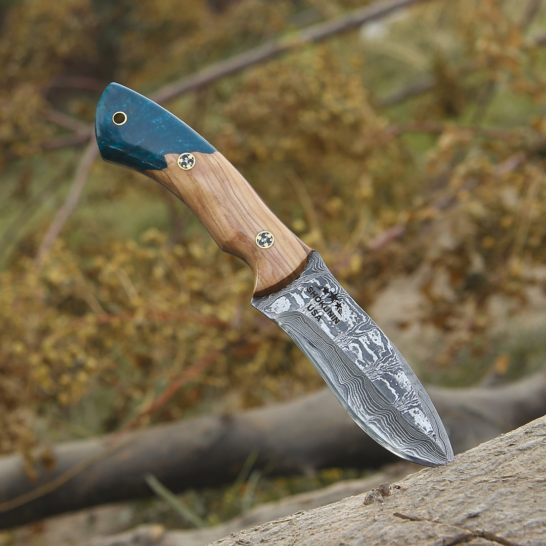Decorative knife with a wooden handle and engraved blade on a natural background