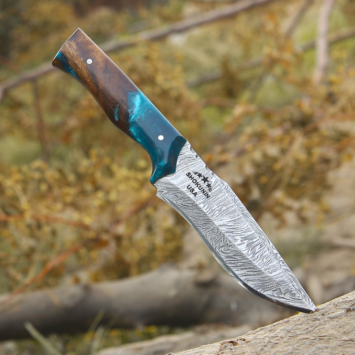 Decorative knife with a wooden handle and blue inlay on a natural background
