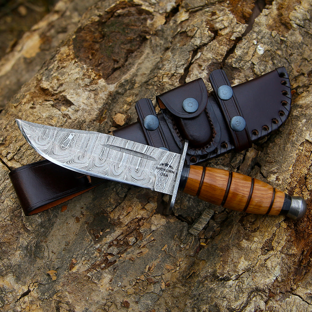 Decorative knife with wooden handle and leather sheath on a textured stone surface