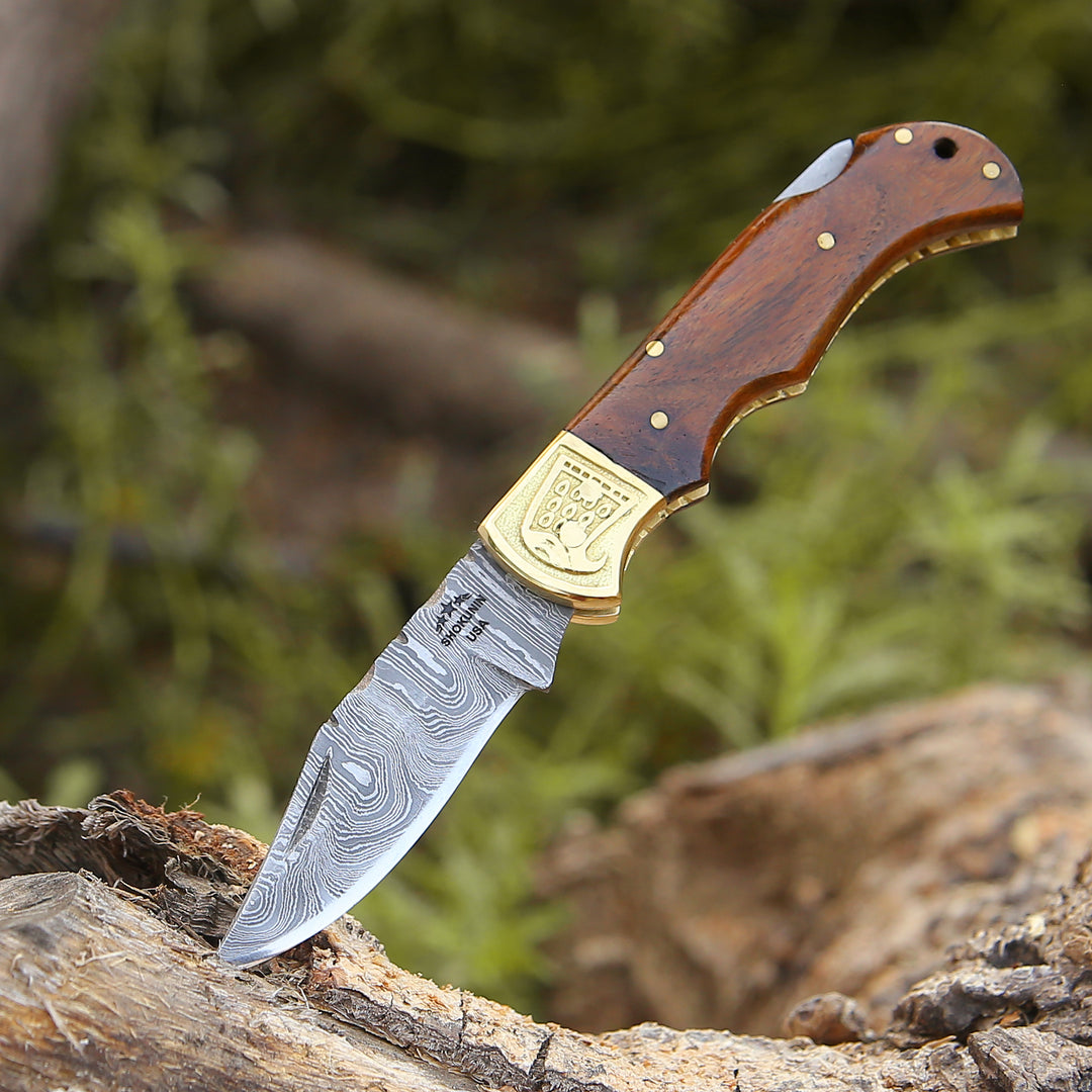Knife with wooden handle and gold emblem on a natural background